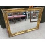 A ModERN GILT FRAMED WALL MIRROR, 43X31"