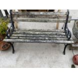 A WOODEN SLATTED GARDEN BENCH WITH CAST BENCH ENDS