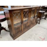 AN OAK GLAZED AND LEADED BOOKCASE WITH CARVED PANEL DOORS, 55" WIDE