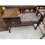 AN OAK TELEPHONE TABLE/SEAT WITH SINGLE CUPBOARD AND PULL-OUT SLIDE