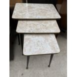 A NEST OF THREE FORMICA TOPPED TABLES ON BLACK TAPERED LEGS