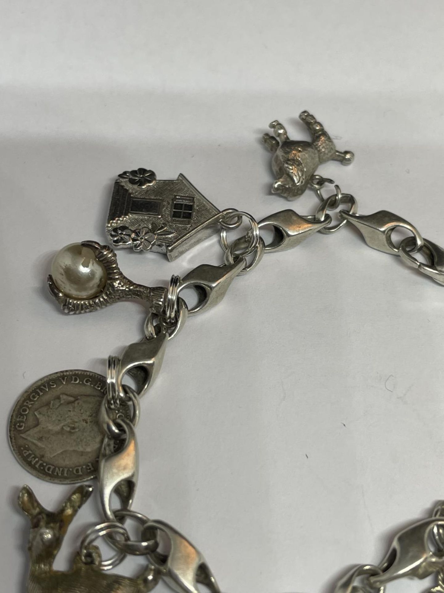 A MARKED SILVER CHARM BRACELET WITH TEN CHARMS TO INCLUDE A HEDGEHOG, SHOE, DOG, TELEPHONE ETC - Image 3 of 4