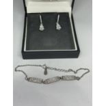A PAIR OF SILVER AND CLEAR STONE EARRINGS AND A MATCHING BRACELET IN A BOX