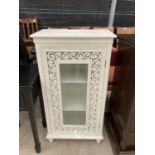 A MODERN PAINTED CABINET WITH GLASS DOOR AND FRETWORK DECORATION 20.5" WIDE