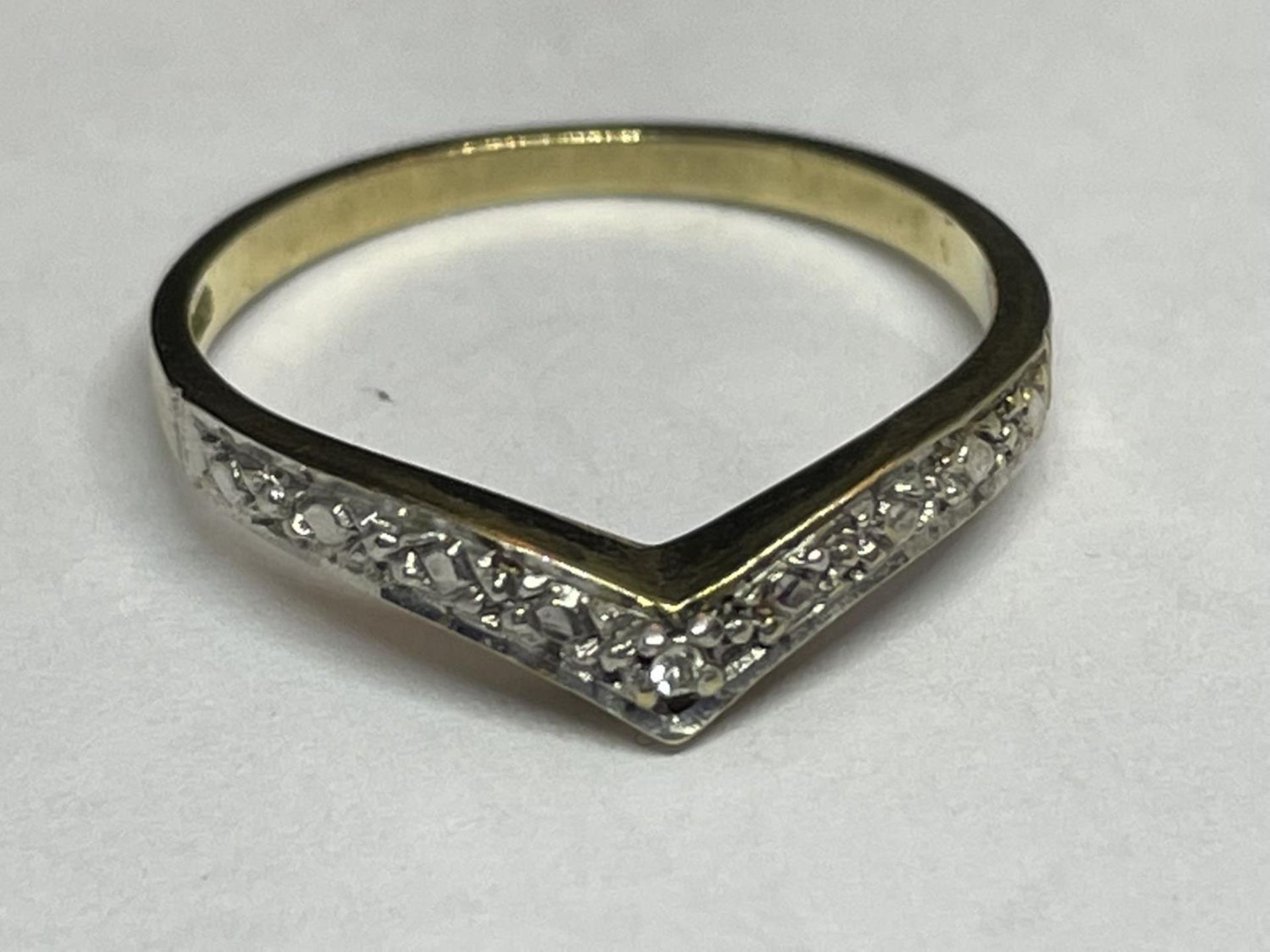 A 9 CARAT GOLD RING WITH DIAMONDS IN A WISHBONE DESIGN SIZE K