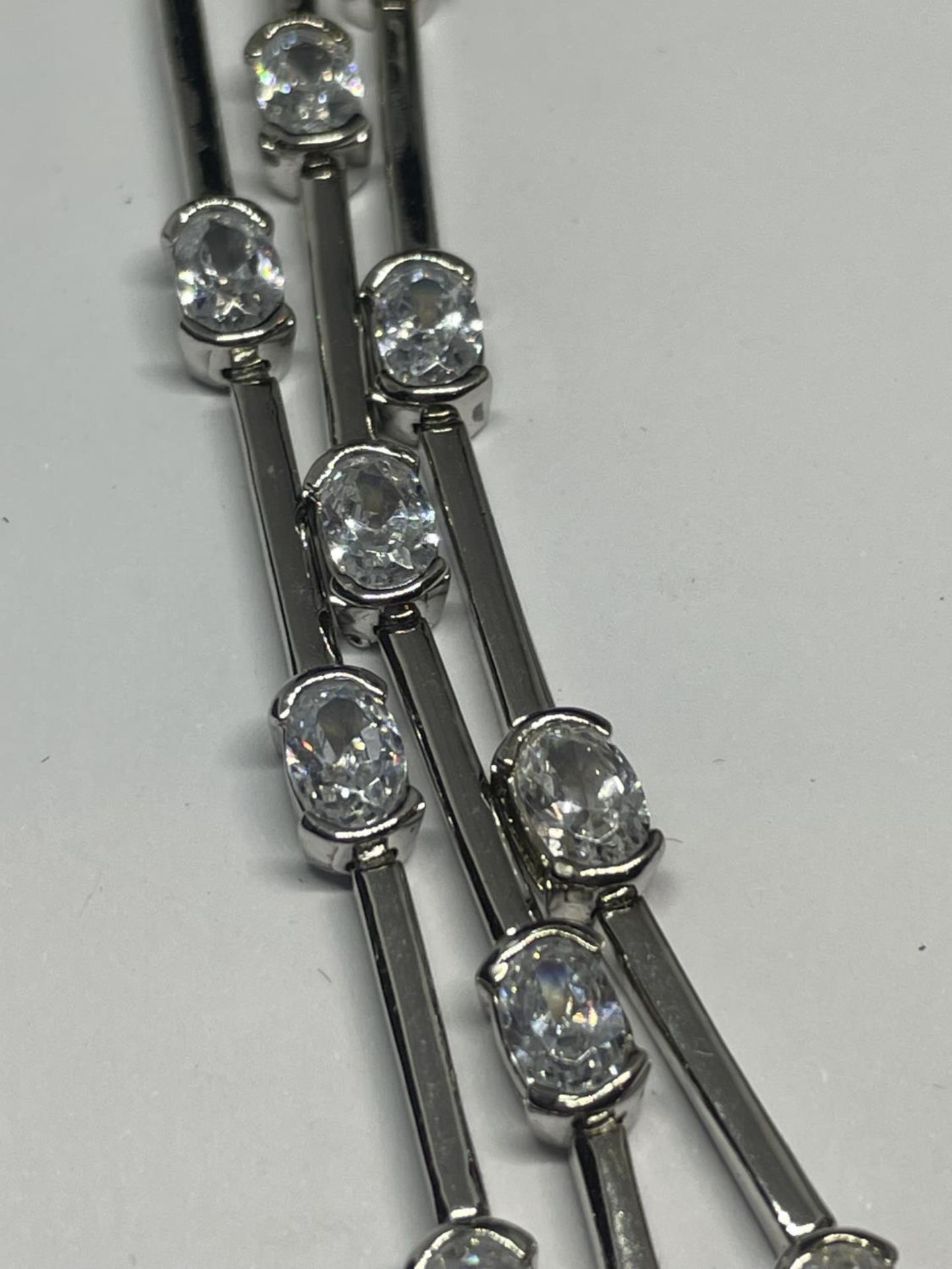 A TRIPLE STRAND SILVER BRACELET WITH CLEAR STONE DECORATION IN A PRESENTATION BOX - Image 3 of 5