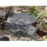 A CIRCULAR METAL GARDEN TABLE WITH FOUR CHAIRS AND A CAST IRON PARASOL BASE