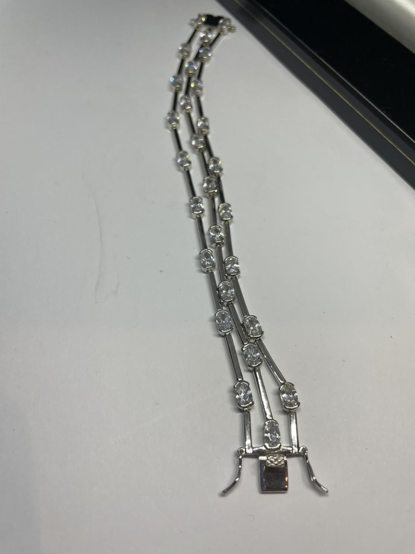 A TRIPLE STRAND SILVER BRACELET WITH CLEAR STONE DECORATION IN A PRESENTATION BOX - Image 2 of 5