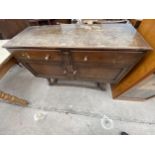 AN EARLY 20TH CENTURY OAK SIDEBOARD ENCLOSING TWO CUPBOARDS AND TWO DRAWERS, ON OPEN BASE WITH SPLAY