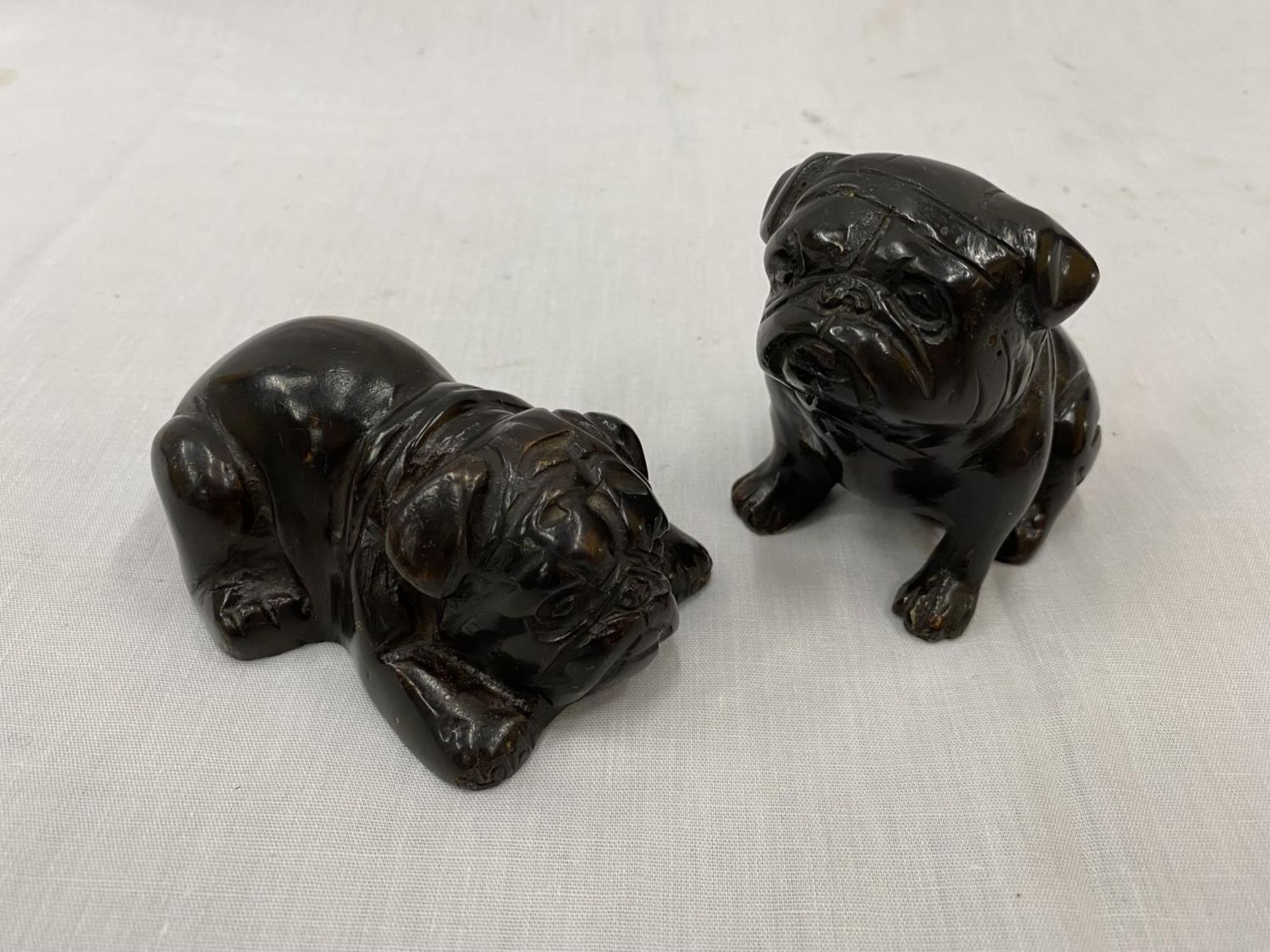 A PAIR OF BRONZE BULLDOGS, ONE SITTING AND ONE LAYING DOWN, HEIGHT 7CM AND 4CM