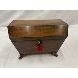 A SARCOPHAGUS SHAPED WALNUT TEA CADDY ON BRASS FEET WITH BRASS SIDE HANDLES, THE INSIDE HAS ONE