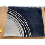 A MEDIUM SIZE BLACK AND GREY PATTERN RUG