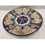 A LARGE IMARI CHARGER WITH HAND PAINTED PANELS RED AND BLUE PATTERNS AND STORKS TO THE RIM, DIAMETER