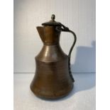 A COPPER AND BRASS SHAPED JUG - BASE TO FINIAL 35 CM