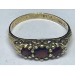 A 9 CARAT GOLD RING WITH THREE IN LINE RED STONES SIZE O