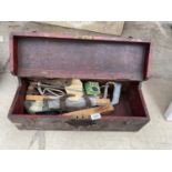 A WOODEN TOOL BOX WITH TOOLS TO IONCLUDE A SAW, STRAP, G CLAMP ETC