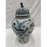 A LARGE HANDMADE ORIENTAL VASE/URN WITH LID. PAINTED IN BLUE AND WHITE THE IMAGES ARE SYMBOLS OF