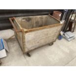 A VINTAGE LAUNDRY TROLLEY ON FOUR CAST IRON WHEELS