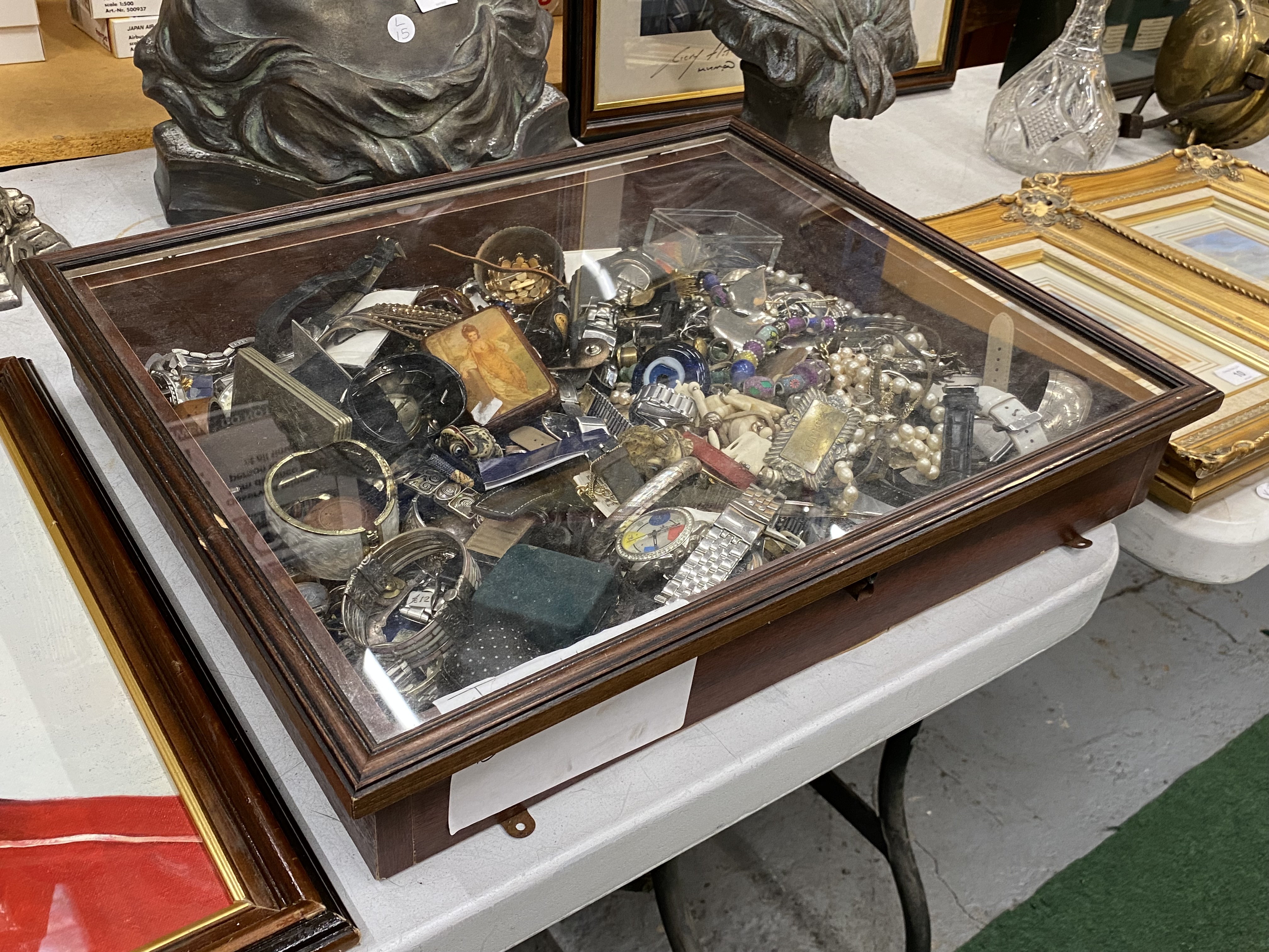 A MAHOGANY GLASS TOPPED DISPLAY CASE CONTAINING A LARGE QUANTITY OF COLLECTABLE ITEMS TO INCLUDE