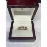 AN 18 CARAT GOLD RING WITH FOUR DIAMONDS AND FIVE RUBIES SIZE M IN A PRESENTATION BOX
