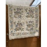 A MEDIUM SIZE WHITE AND MIXED COLOUR PATTERN RUG