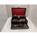 A THREE TIERED JEWELLERY BOX TO INCLUDE A QUANTITY OF COSTUME JEWELLERY INCLUDING BRACELETS,