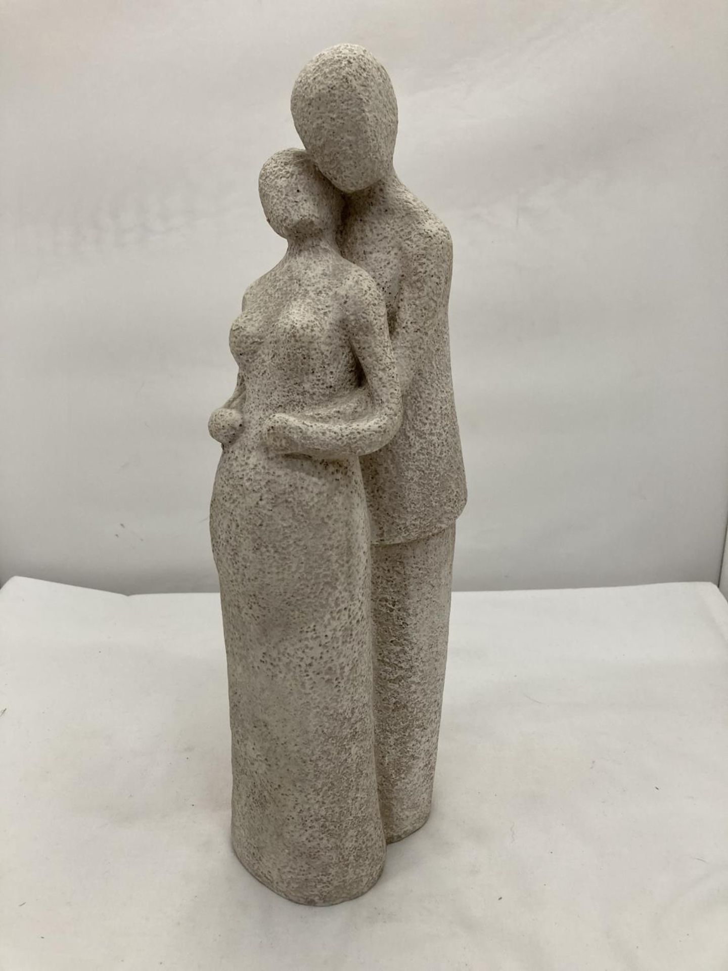 A STONEWARE FIGURINE OF A MAN HOLDING A PREGNANT LADY HEIGHT 38CM