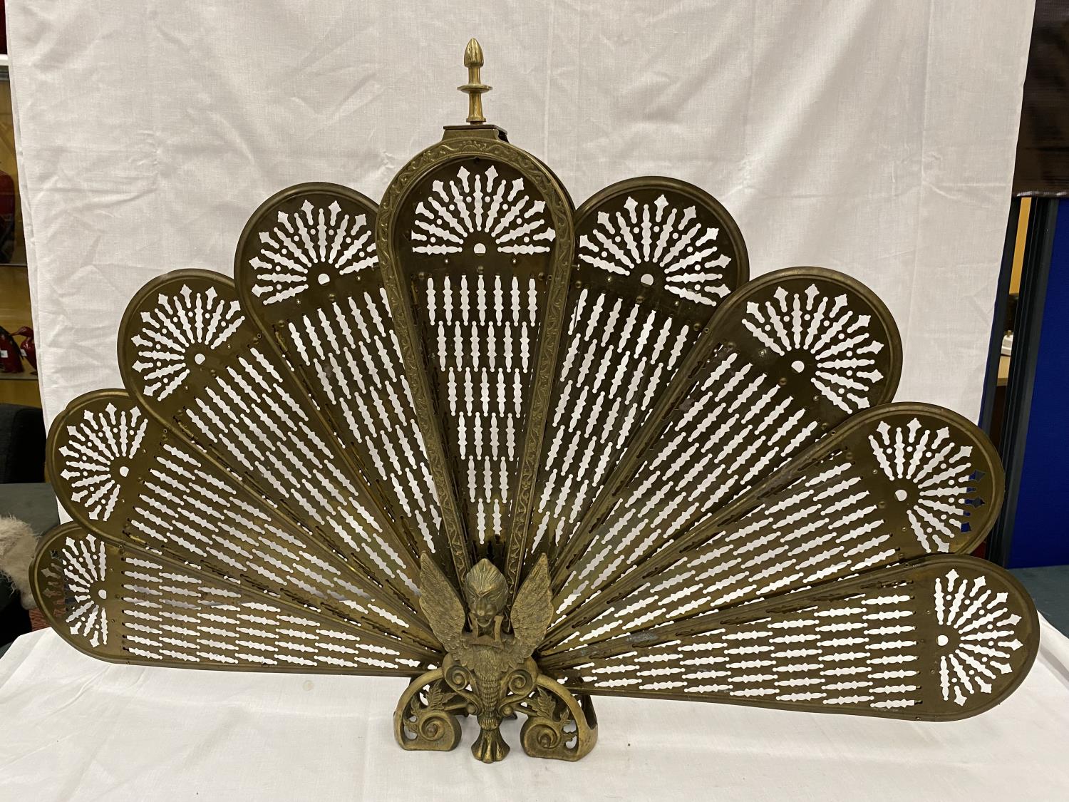 A VINTAGE BRASS PEACOCK FAN FIRE SCREEN WITH WINGED GRIFFIN TO THE BASE, HEIGHT 63CM