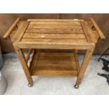 AN OAK DRINKS TROLLEY WITH BOTTLE HOLDER AND REMOVABLE TRAY