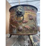 A VERY LARGE DECORATIVE BRASS AND COPPER BUCKET ON THREE CLAW FEET AND LION DESIGN HANDLES WITH