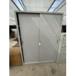 A LARGE TWO DOOR METAL CUPBOARD WITH SLIDING DOORS