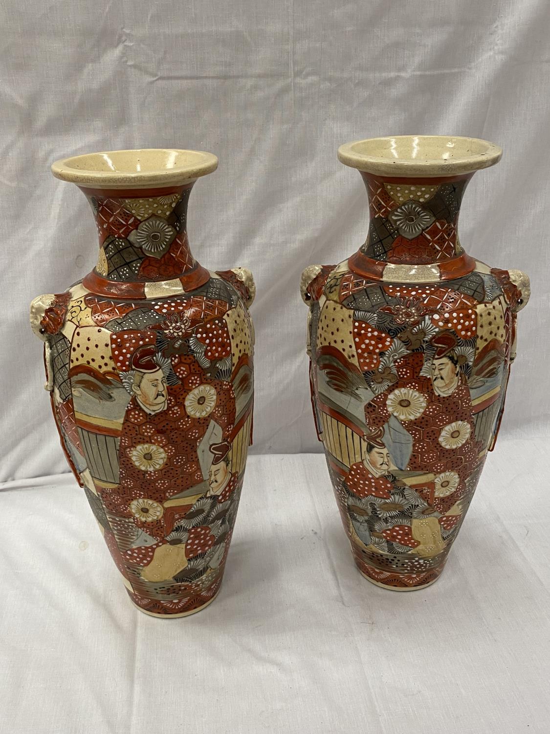 A PAIR OF ORIENTAL STYLE VASES WITH EMBOSSED DECORATION HEIGHT 45CM - A/F CRACKS TO BOTH