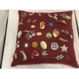 A CUSHION CONTAINING COSTUME JEWELLERY TO INCLUDE ANIMALS, FLOWERS, SCOTTISH STYLE, ETC
