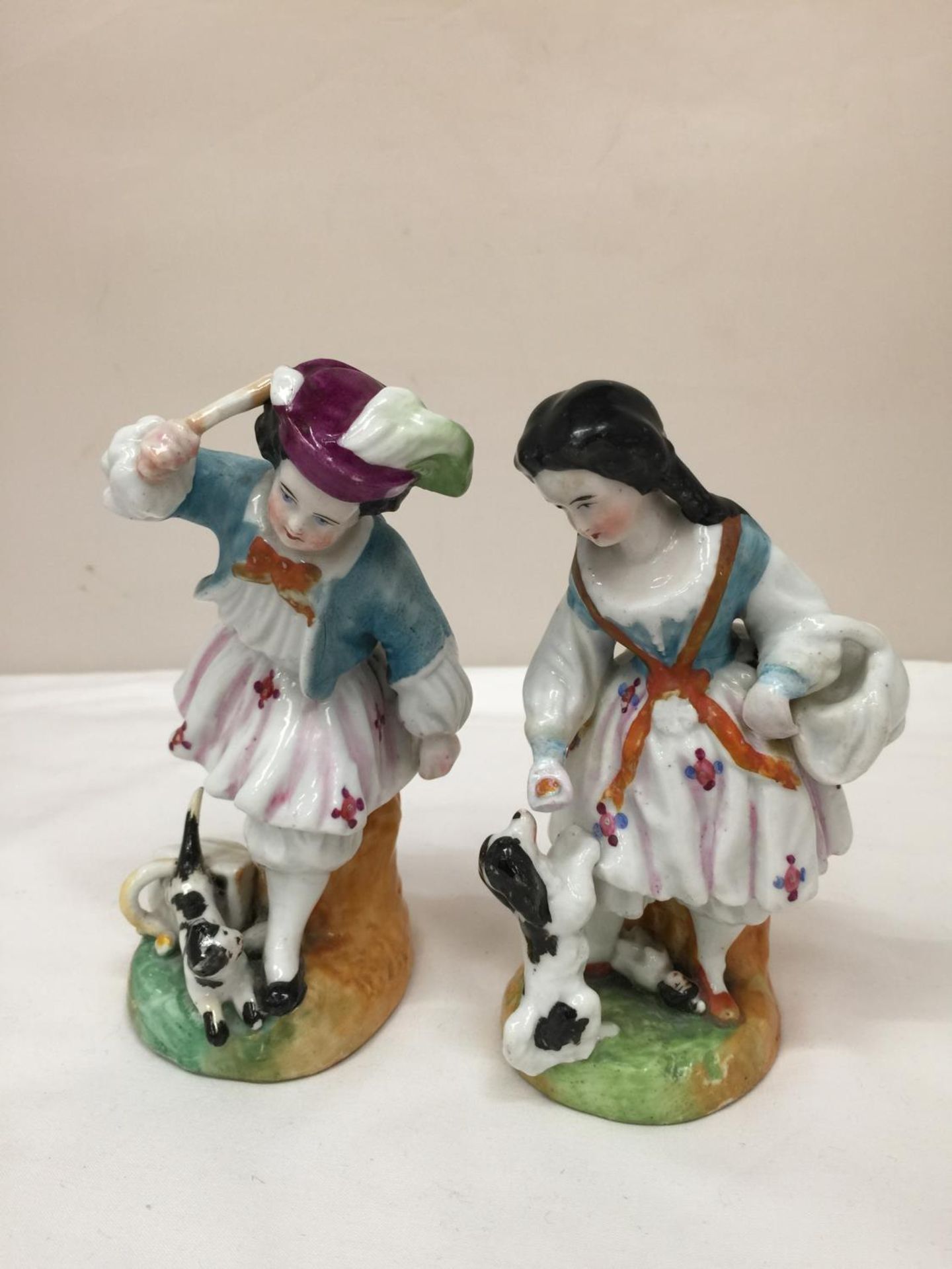 A PAIR OF EARLY STAFFORDSHIRE HARD PASTE PORCELAIN FIGURES OF A BOY AND A GIRL WITH DOGS HEIGHT BOTH