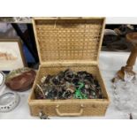 A WICKER PICNIC BASKET CONTAINING A QUANTITY OF COSTUME JEWELLERY TO INCLUDE BANGLES, NECKLACES,