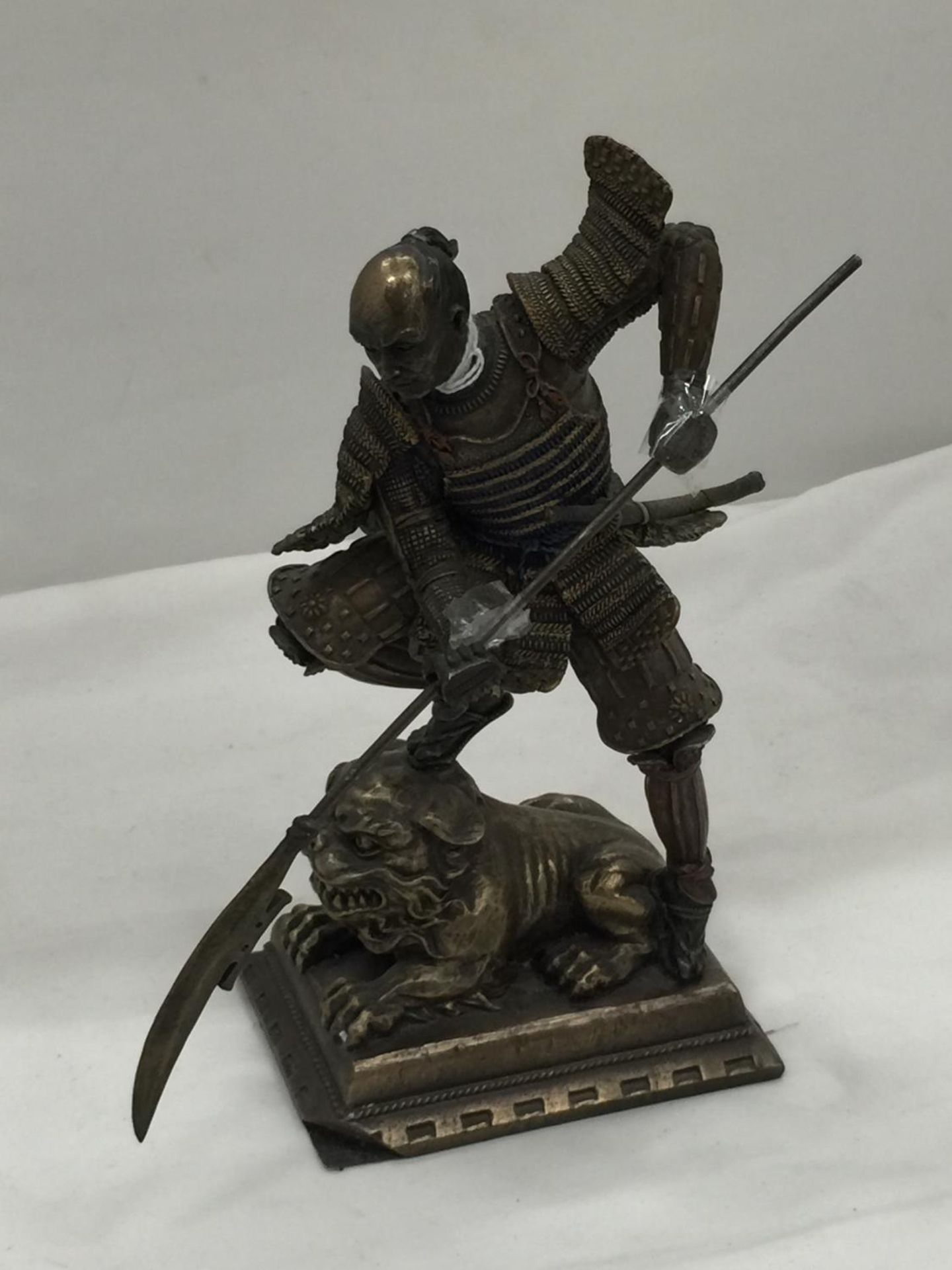 A METAL FIGURE OF A SAMURAI WARRIOR STANDING ON A LION HEIGHT 24CM