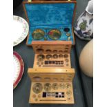 A SET OF BRASS TRAVELLING SCALES AND TWO SETS OF BRASS WEIGHTS ALL IN WOODEN BOXES