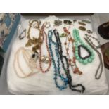 A CUSHION CONTAINING A QUANTITY OF COSTUME JEWELLERY TO INCLUDE NECKLACES, BRACELETS, RINGS,