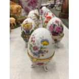 ELEVEN PORCELAIN HINGED FOOTED TRINKET BOXES IN THE SHAPE OF EGGS
