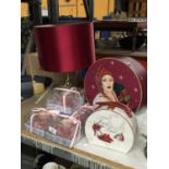 A BRASS TABLE LAMP WITH A BURGUNDY LAMP SHADE, DECORATIVE BOX BOXED CANDLES IN CUPS, ETC