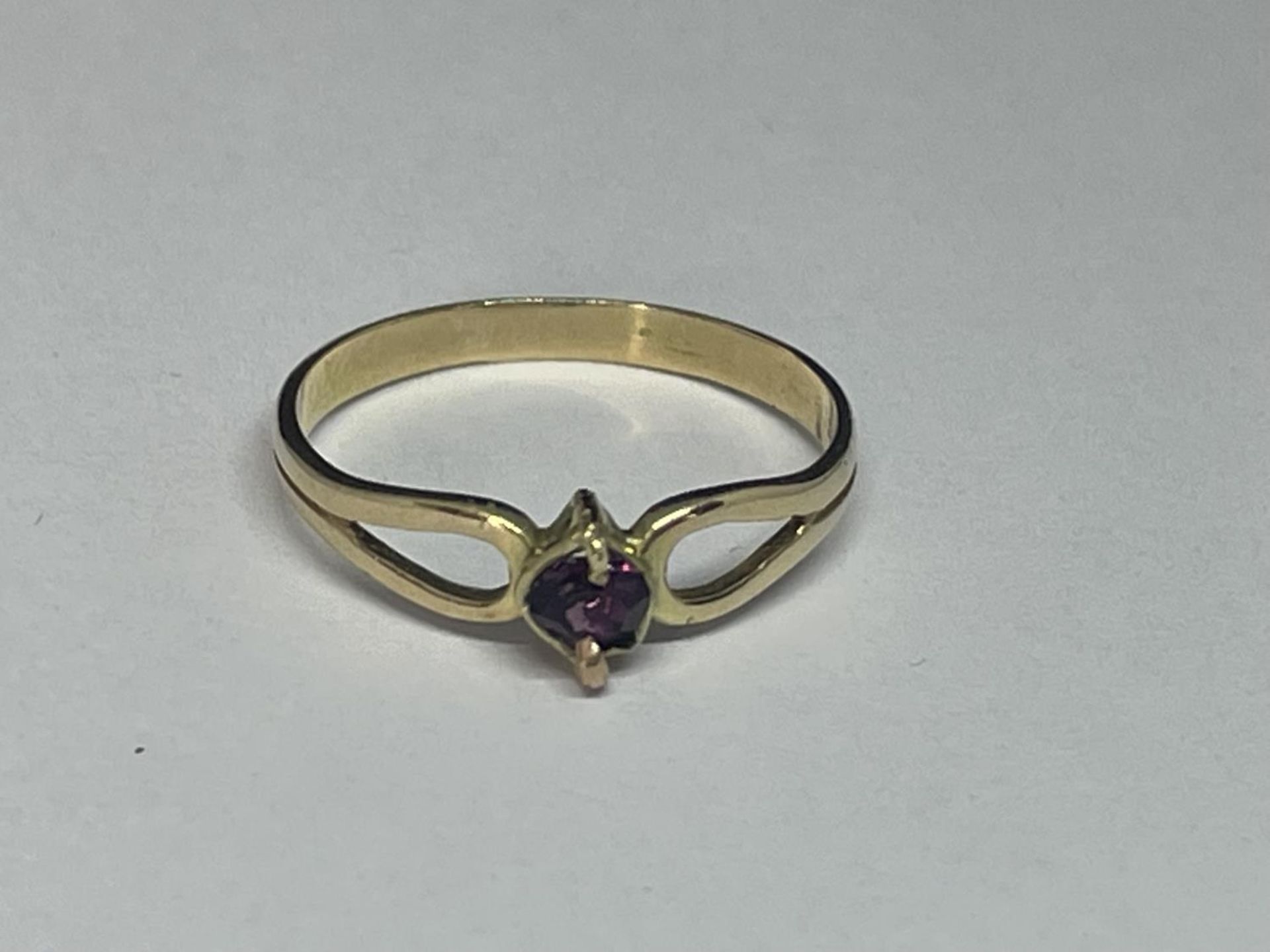 A 14 CARAT GOLD RING WITH A SINGLE PURPLE STONE SIZE M/N IN A PRESENTATION BOX
