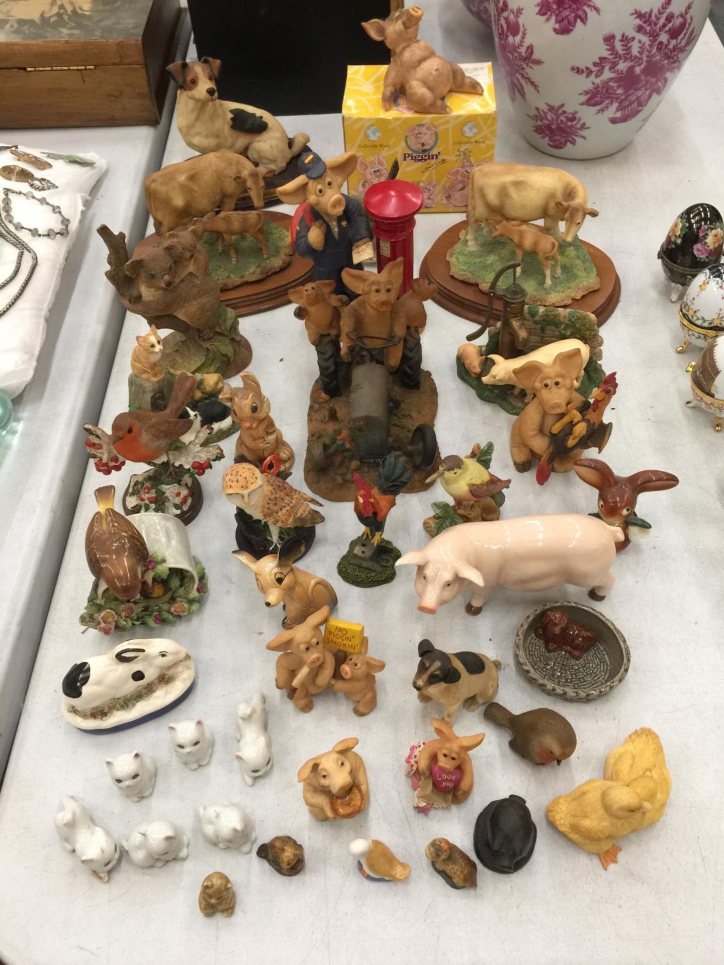 A LARGE QUANTITY OF CERAMIC AND RESIN ANIMAL FIGURES TO INCLUDE PIGGIN', LEONARDO MODELS OF COWS AND