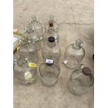 A COLLECTION OF TEN GLASS DEMI JOHNS AND FLAGGONS TO INCLUDE SOME NAMED