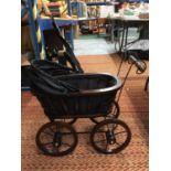A VINTAGE STYLE WOODEN DOLL'S PRAM WITH METAL SUSPENSION, A HOOD AND BLACK FITTED INTERIOR