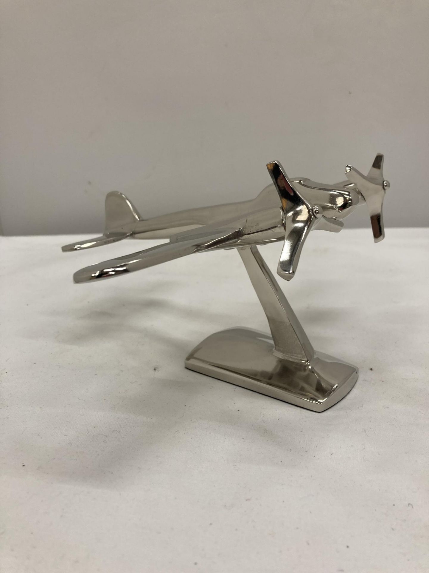 A CHROME MODEL OF A WW11 BOMBER ON STAND HEIGHT 10 CM, LENGTH 17 CM