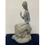 A MIQUEL REQUENA LLADRO STYLE PORCELAIN FIGURINE OF A SITTING GIRL WITH A BIRD IN HER HAND - 28CM IN