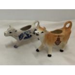 A DELFT BLUE HANDPAINTED COW CREAMER AND A JERSEY COW CREAMER
