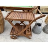 A TEAK DRINKS TROLLEY WITH TWO REMOVABLE TRAYS AND A BOTTLE CARRIER