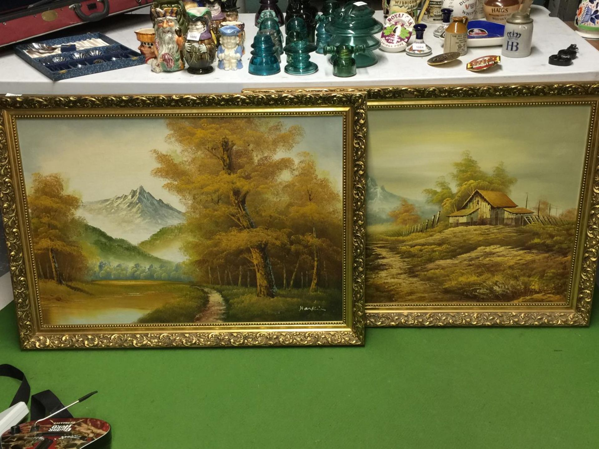 A PAIR OF SCENIC OIL 'S ON BOARD IN GOLD ORNATE FRAMES BOTH SIGNED - 103 X 76 CM TO INCLUDE FRAME