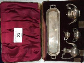 A SET OF BIRMINGHAM HALLMARKED SILVER MINIATURE TEAPOTS AND JUGS IN A CASE